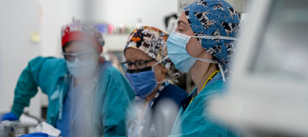 Trois professionnels de la santé poussent une civière.