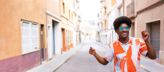 personne avec des lunettes de soleil marchant dans une rue vide